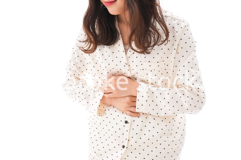 腹痛で苦しむ若い女性
