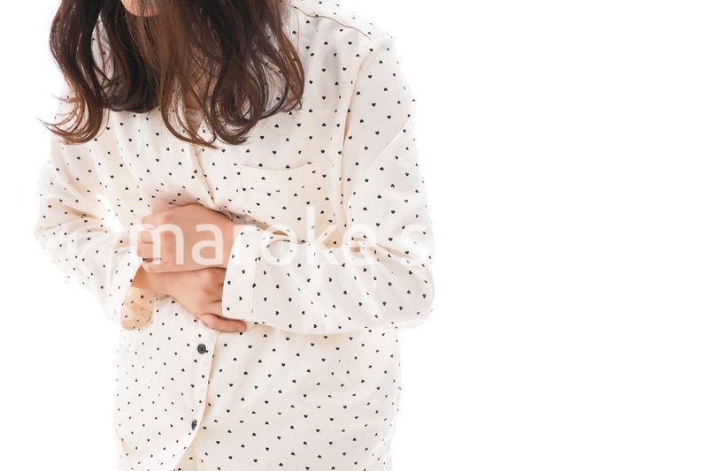 腹痛で苦しむ若い女性