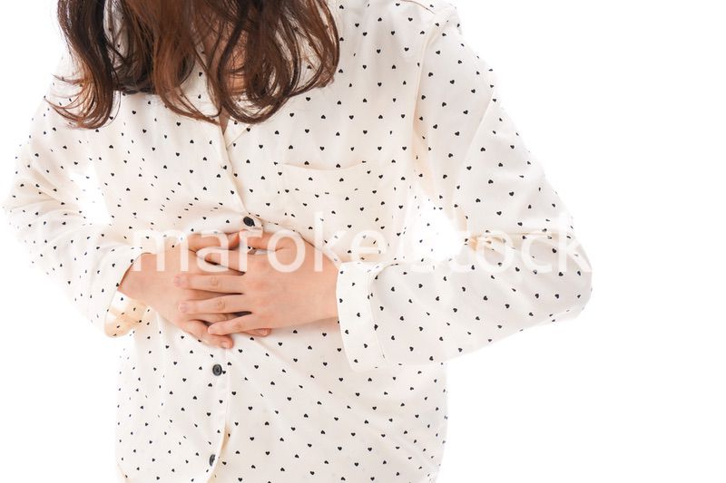 腹痛で苦しむ若い女性