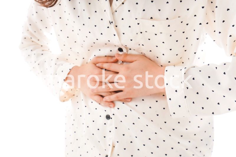腹痛で苦しむ若い女性