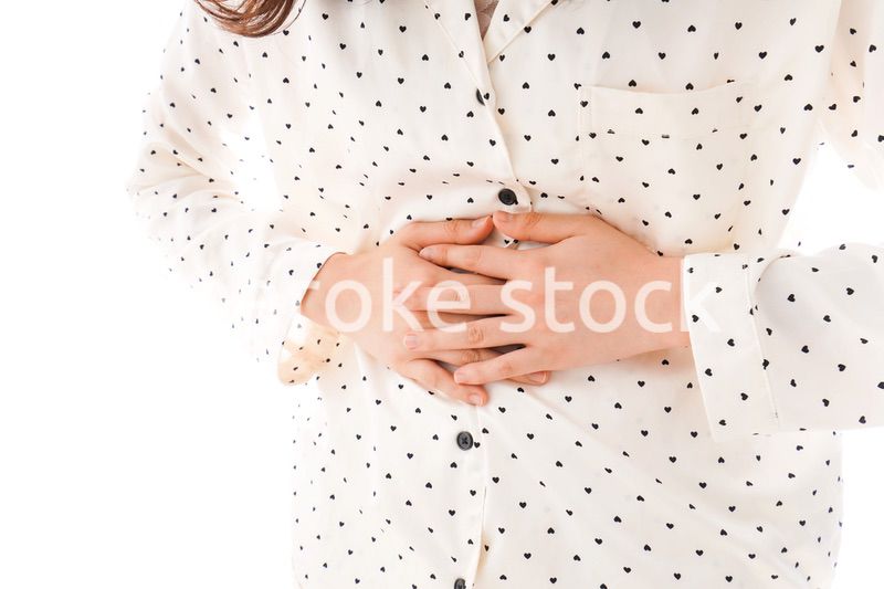 腹痛で苦しむ若い女性
