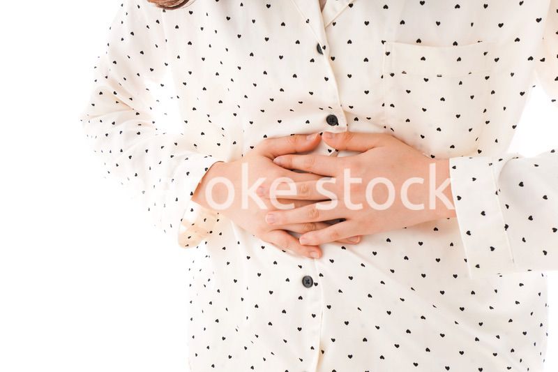 腹痛で苦しむ若い女性