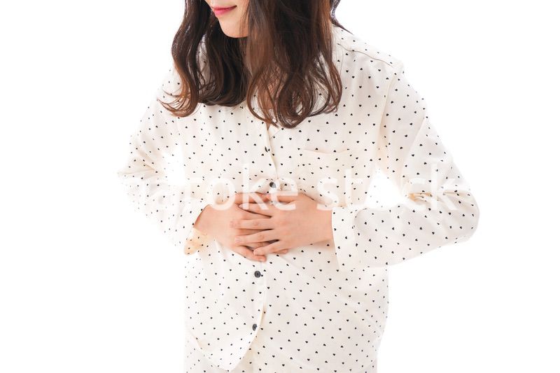 腹痛で苦しむ若い女性