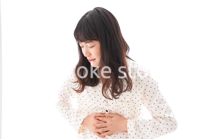 腹痛で苦しむ若い女性