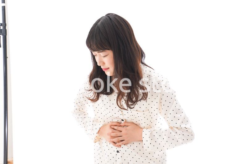 腹痛で苦しむ若い女性