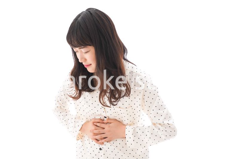 腹痛で苦しむ若い女性