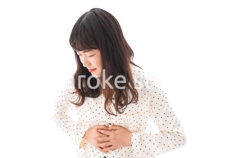 腹痛で苦しむ若い女性