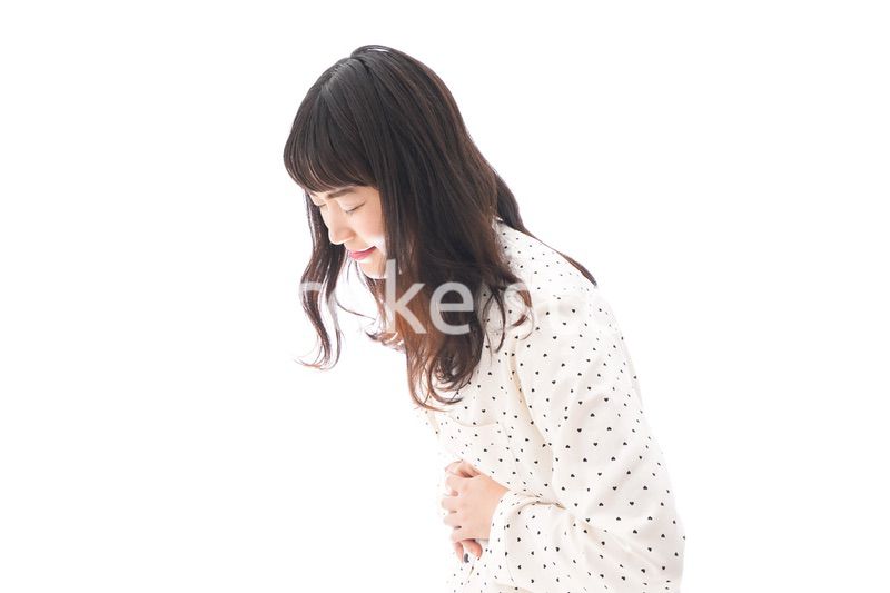 腹痛で苦しむ若い女性