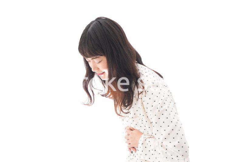 腹痛で苦しむ若い女性