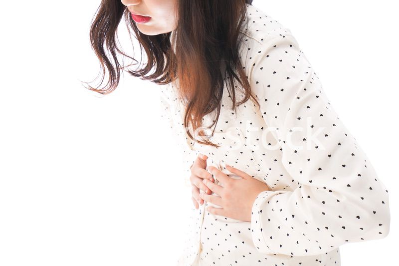 腹痛で苦しむ若い女性