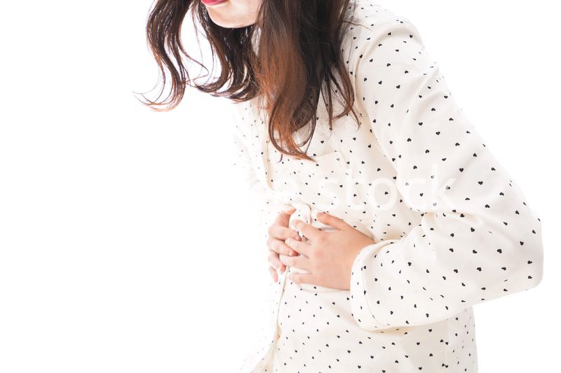 腹痛で苦しむ若い女性