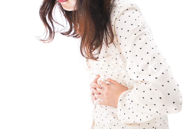 腹痛で苦しむ若い女性