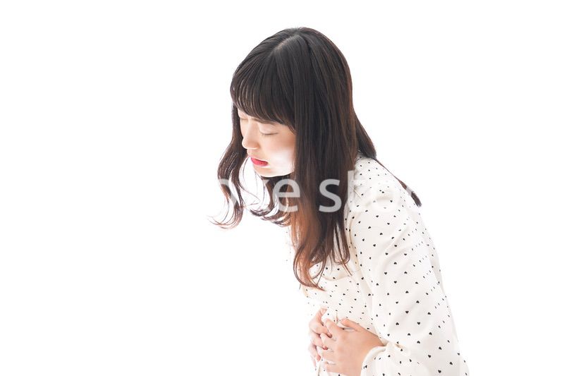 腹痛で苦しむ若い女性