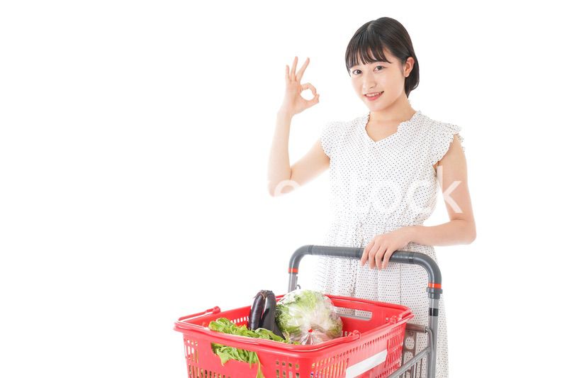 スーパーでOKサインをする若い女性