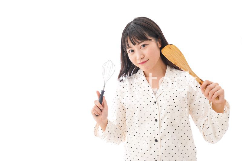 エプロンを着てごはんを作る若い女性