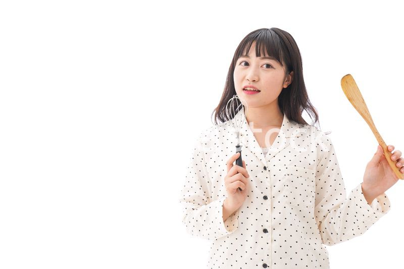 エプロンを着てごはんを作る若い女性