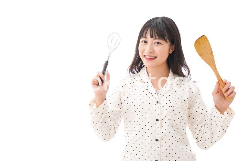 エプロンを着てごはんを作る若い女性