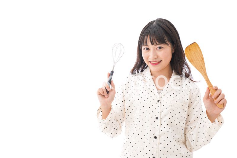 エプロンを着てごはんを作る若い女性