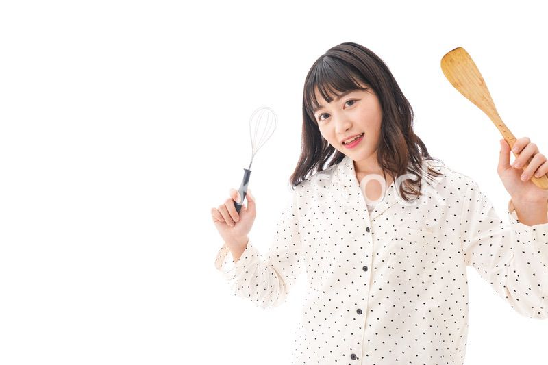 エプロンを着てごはんを作る若い女性