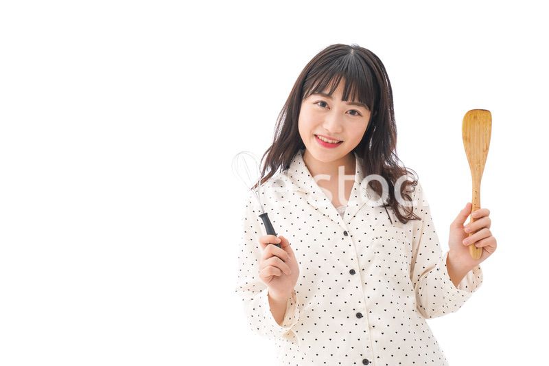 エプロンを着てごはんを作る若い女性