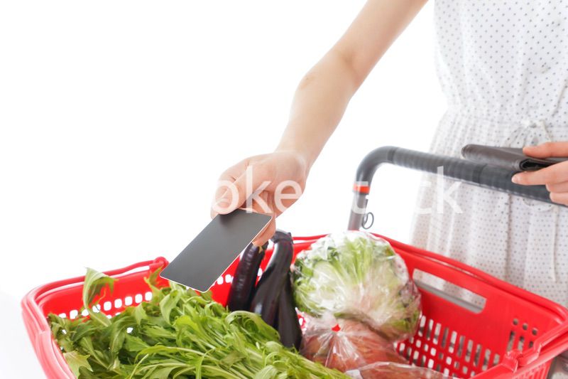 スーパーでキャッシュレス決済をする若い女性