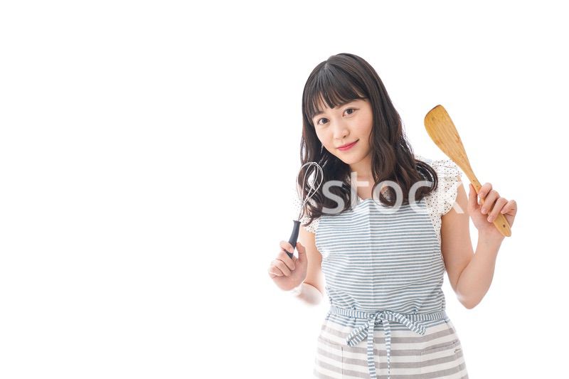 エプロンを着てごはんを作る若い女性