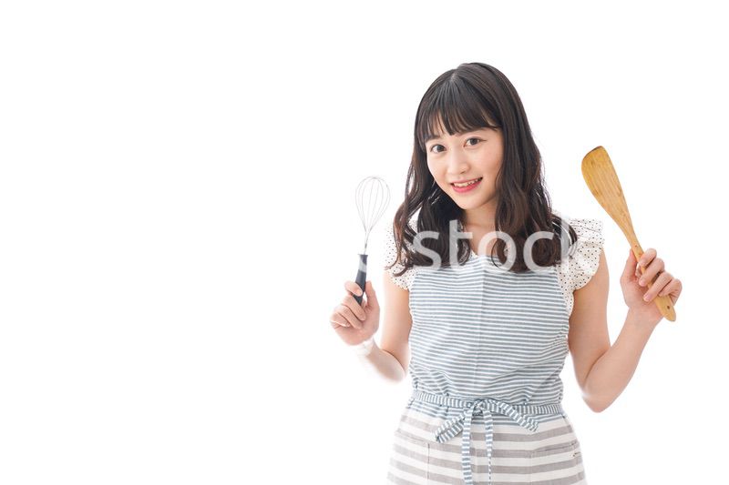 エプロンを着てごはんを作る若い女性