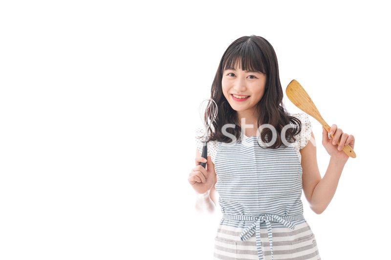 エプロンを着てごはんを作る若い女性