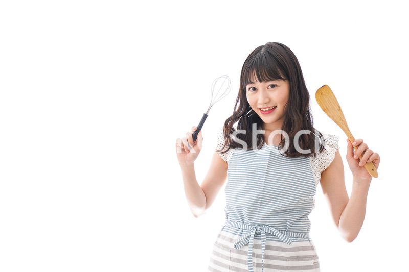 エプロンを着てごはんを作る若い女性
