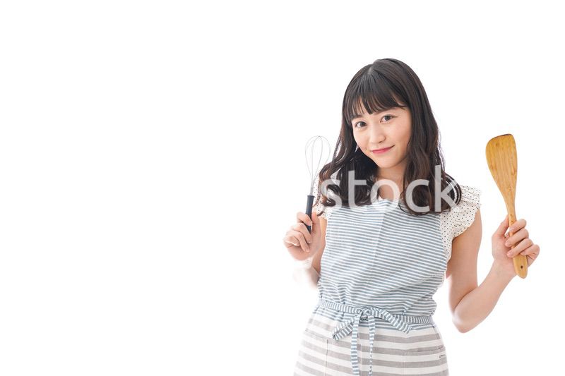 エプロンを着てごはんを作る若い女性