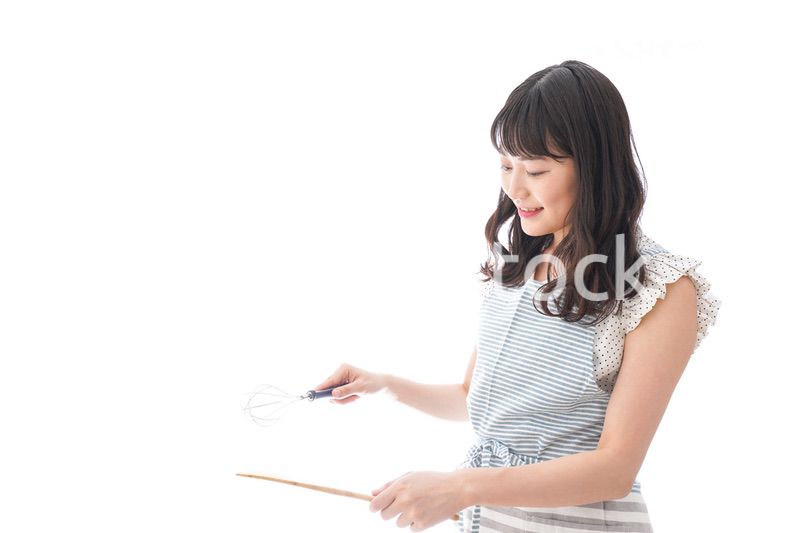 エプロンを着てごはんを作る若い女性