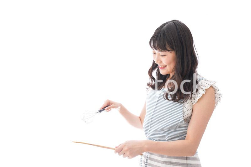 エプロンを着てごはんを作る若い女性