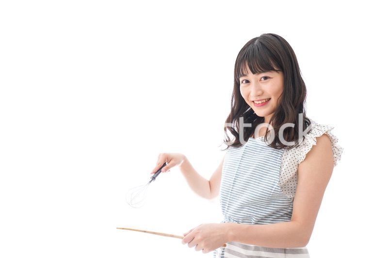 エプロンを着てごはんを作る若い女性