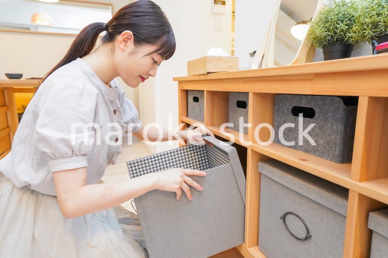 棚の片付けをする若い女性