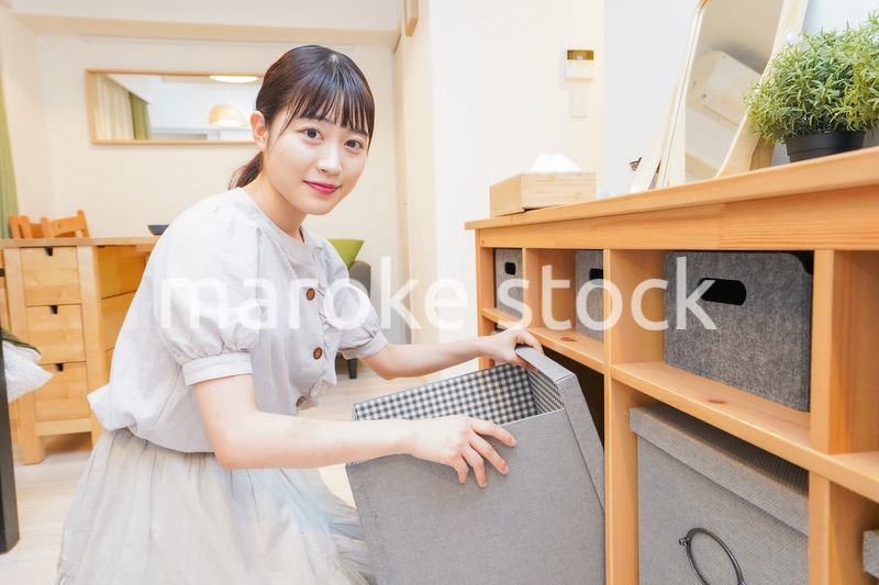 棚の片付けをする若い女性