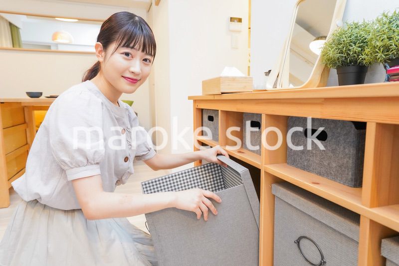 棚の片付けをする若い女性