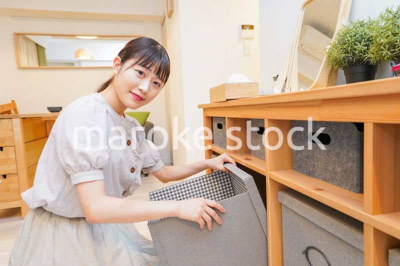 棚の片付けをする若い女性