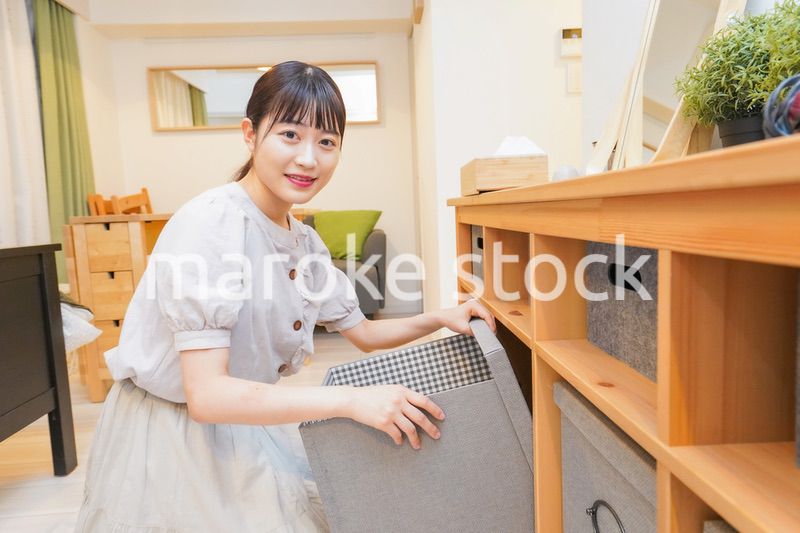 棚の片付けをする若い女性