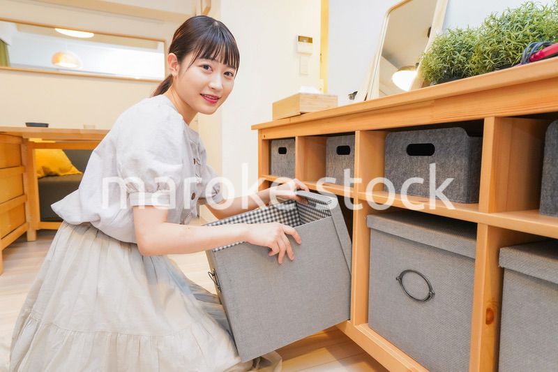 棚の片付けをする若い女性