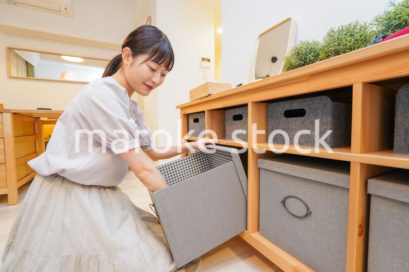 棚の片付けをする若い女性