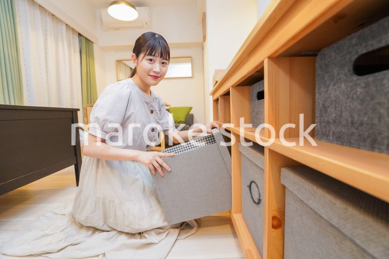 棚の片付けをする若い女性