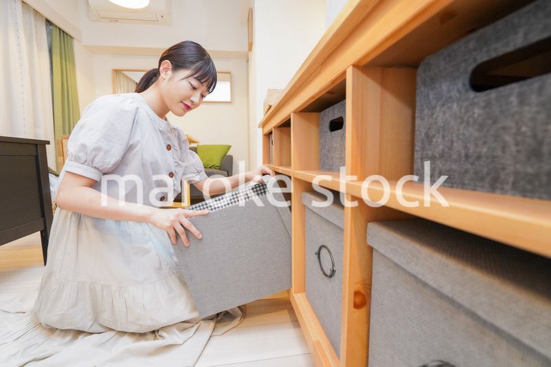 棚の片付けをする若い女性