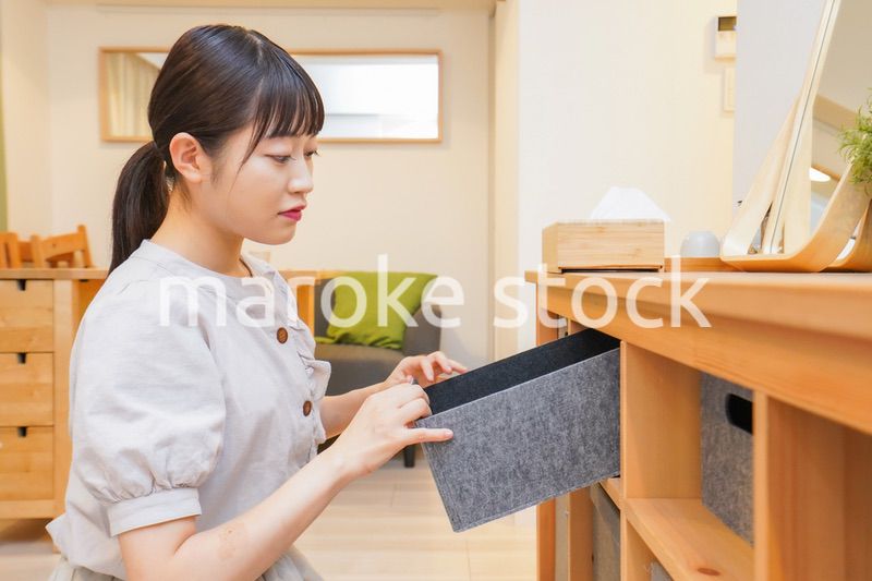 棚の片付けをする若い女性
