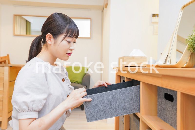 棚の片付けをする若い女性