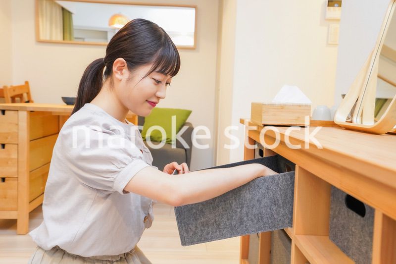 棚の片付けをする若い女性