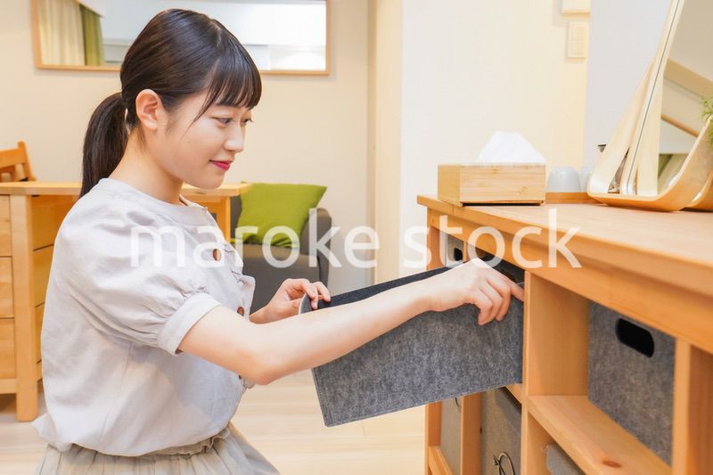 棚の片付けをする若い女性
