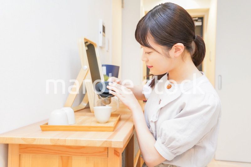 お茶を入れる若い女性