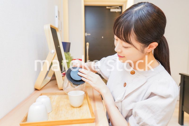 お茶を入れる若い女性