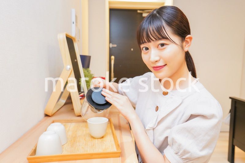 お茶を入れる若い女性