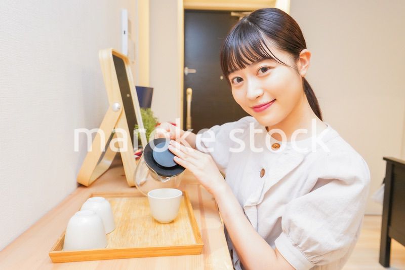 お茶を入れる若い女性